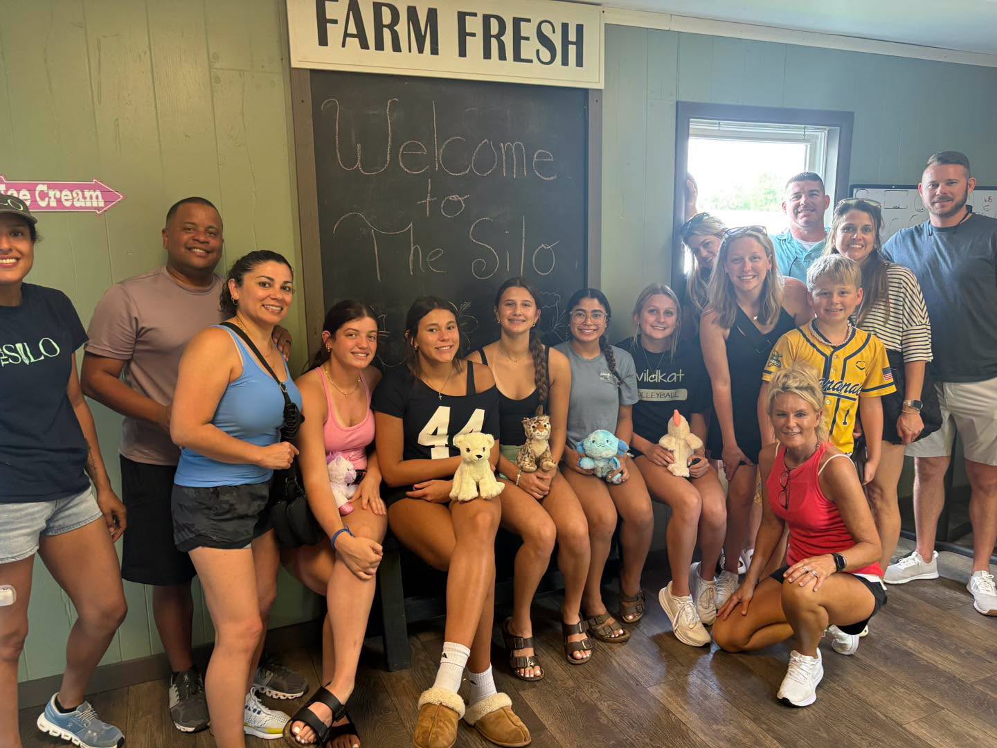 A happy group under the Welcome to The Silo / Farm Fresh chalkboard