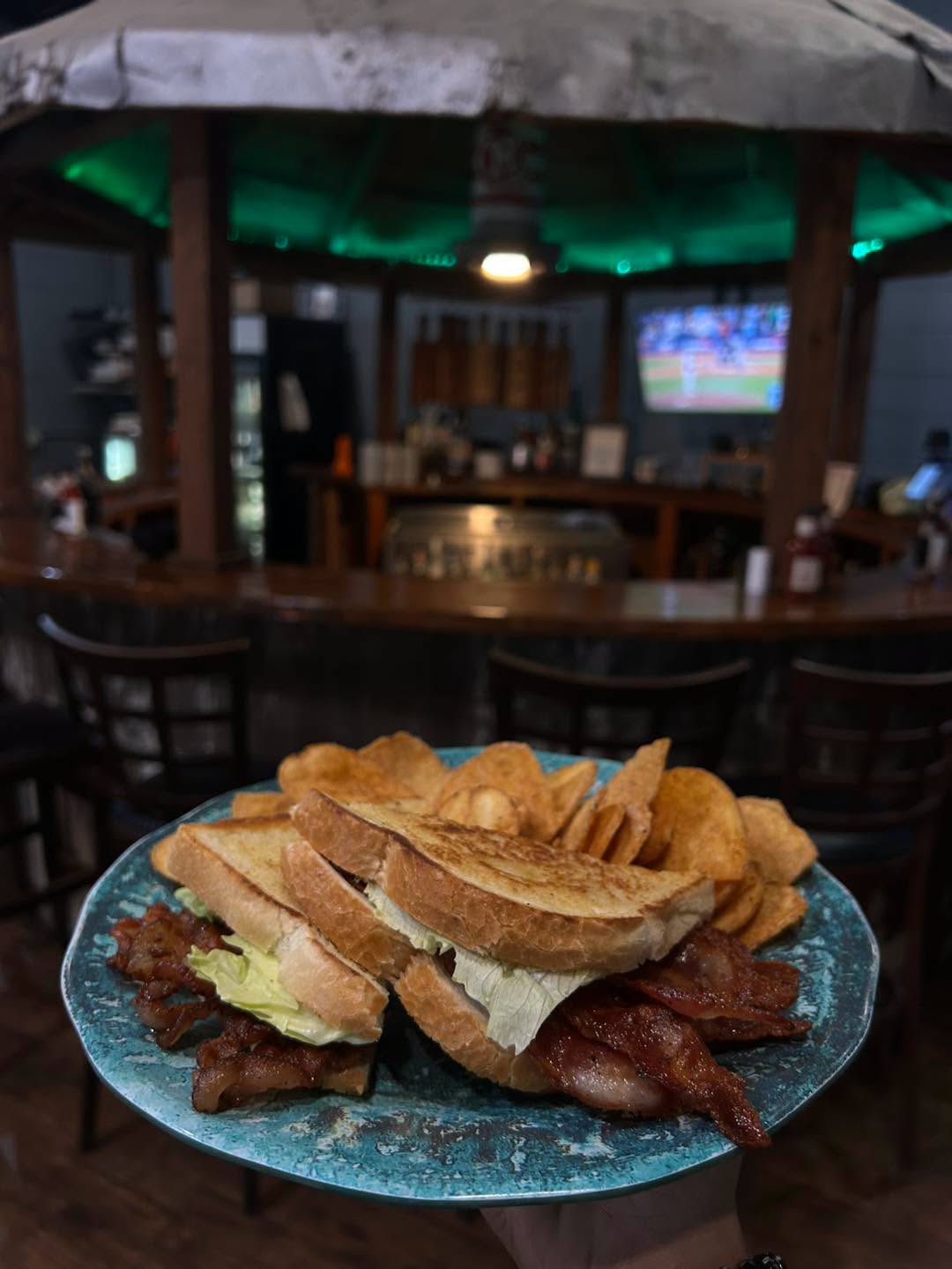 A stacked BLT with kettle chips at the bar