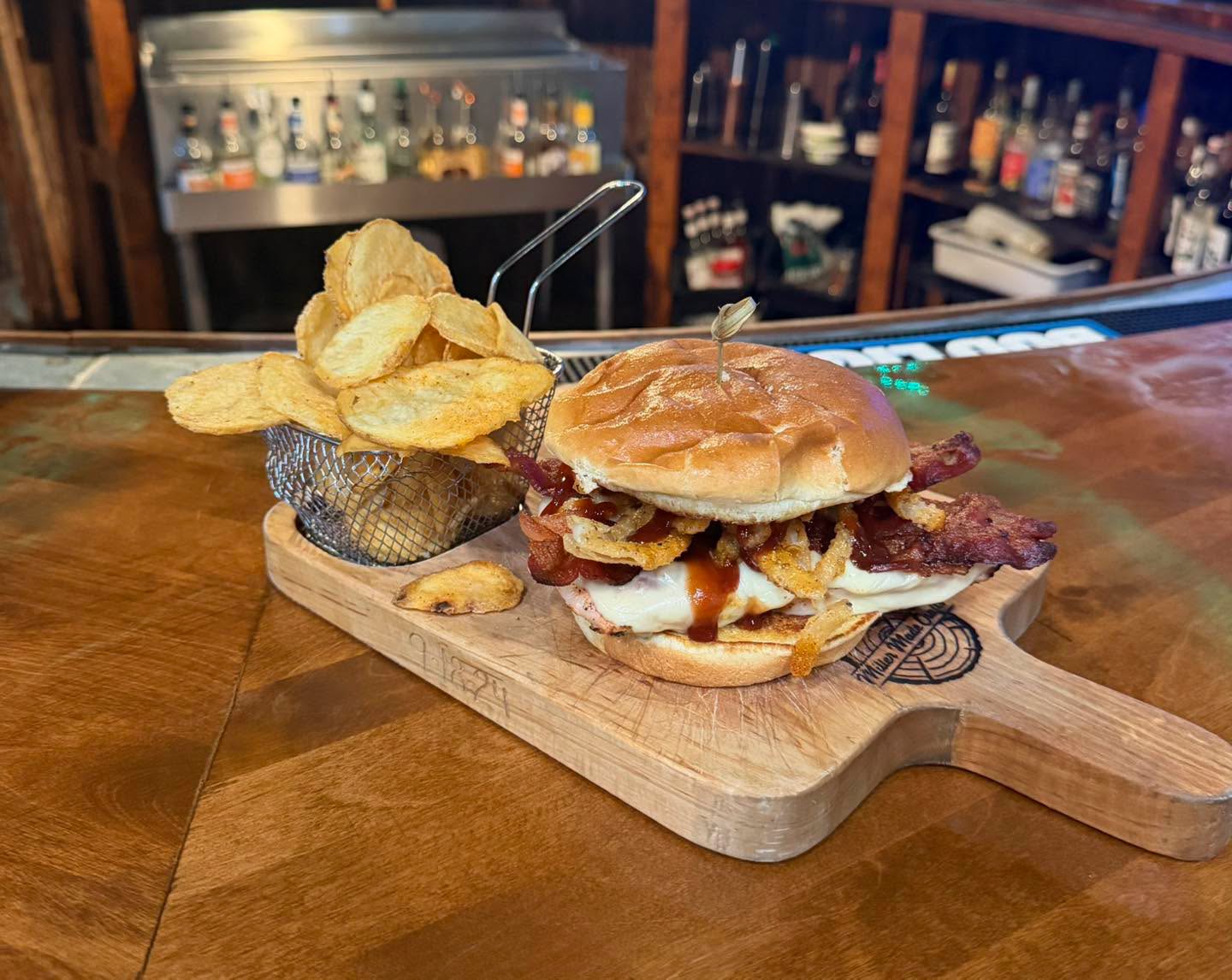 BBQ bacon chicken sandwich on a wooden board at the bar
